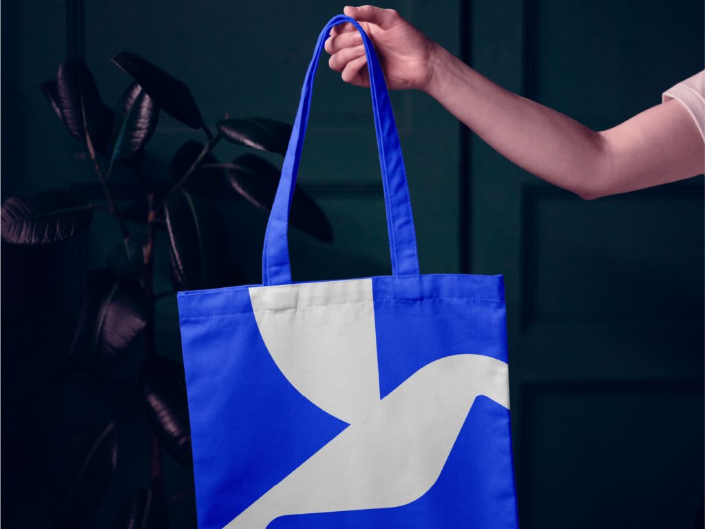 Aerius brand identity design applied to a blue and white tote bag